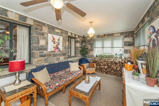 living area featuring ceiling fan, ornamental molding, and carpet flooring