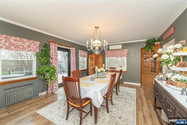 dining space featuring crown molding, a chandelier, a wall unit AC, and radiator
