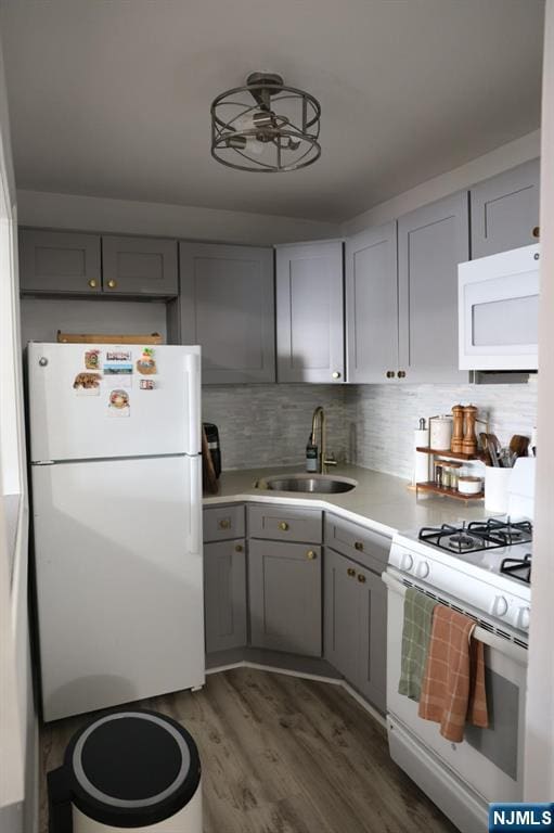 25 River Unit B10, Nutley, NJ 07110 - kitchen featuring light countertops, gray cabinets, a sink, dark wood-type flooring, and white appliances
