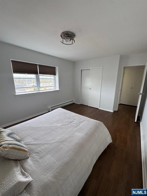 25 River Unit B10, Nutley, NJ 07110 - bedroom featuring baseboards, a closet, dark wood-type flooring, and a baseboard radiator