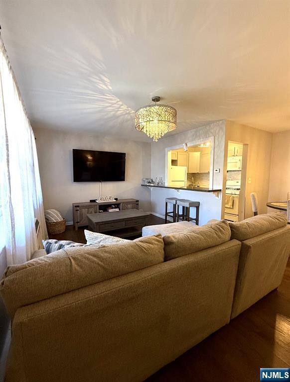 25 River Unit B10, Nutley, NJ 07110 - living area featuring dark wood finished floors and a notable chandelier