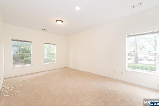 empty room with light carpet, baseboards, and visible vents
