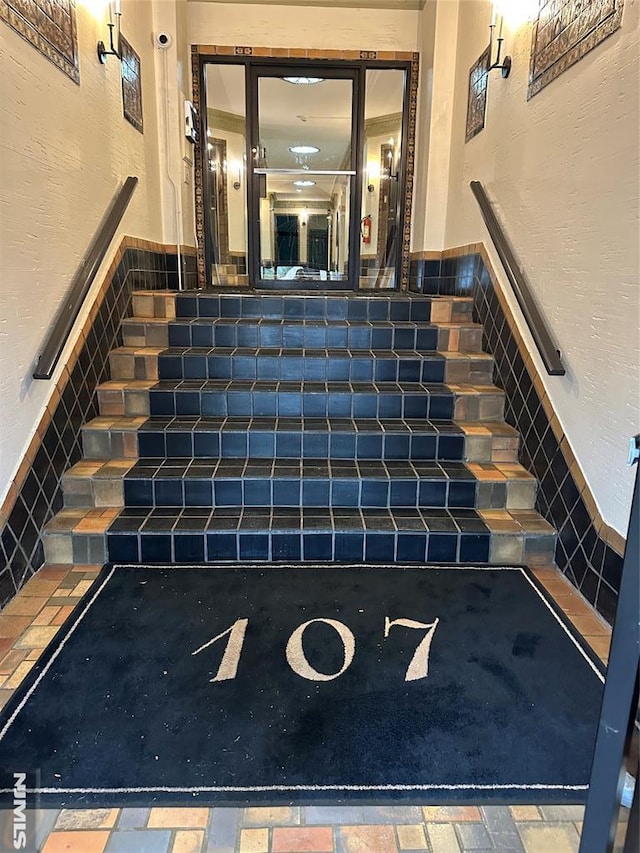 staircase featuring wainscoting