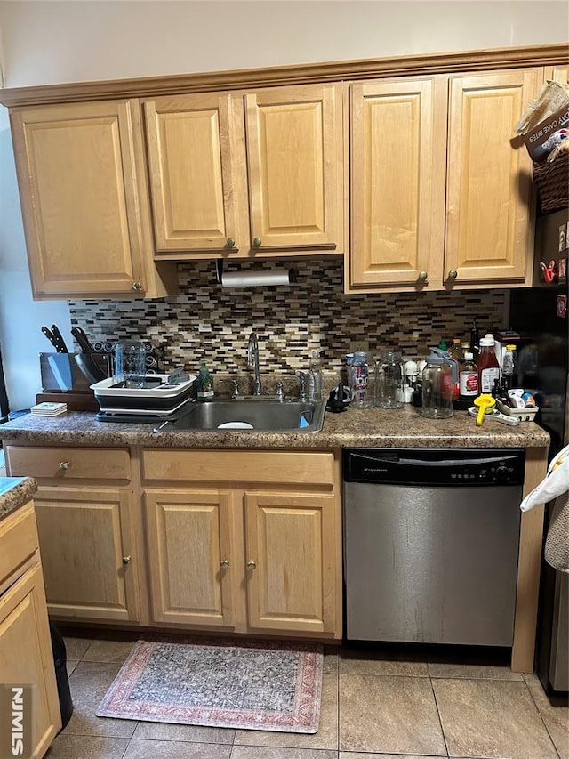 kitchen with light brown cabinets, stainless steel dishwasher, tasteful backsplash, and a sink