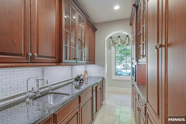 22 Nottingham Ct, Ringwood, NJ 07456 - kitchen featuring a sink, backsplash, stone tile flooring, dark stone countertops, and baseboards
