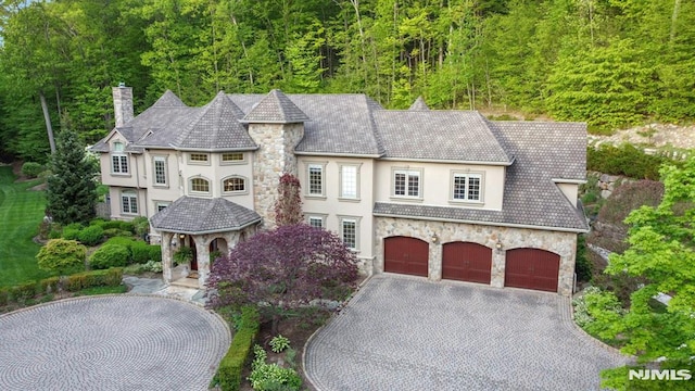 22 Nottingham Ct, Ringwood, NJ 07456 - french country inspired facade with stone siding, stucco siding, a chimney, and driveway