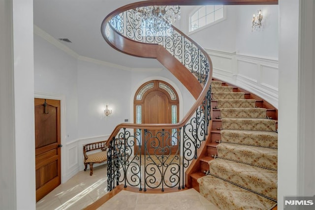 22 Nottingham Ct, Ringwood, NJ 07456 - stairs featuring crown molding, a decorative wall, tile patterned flooring, and a wainscoted wall
