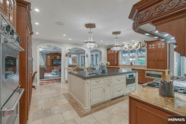 22 Nottingham Ct, Ringwood, NJ 07456 - kitchen featuring arched walkways, recessed lighting, dark stone countertops, a chandelier, and cream cabinets
