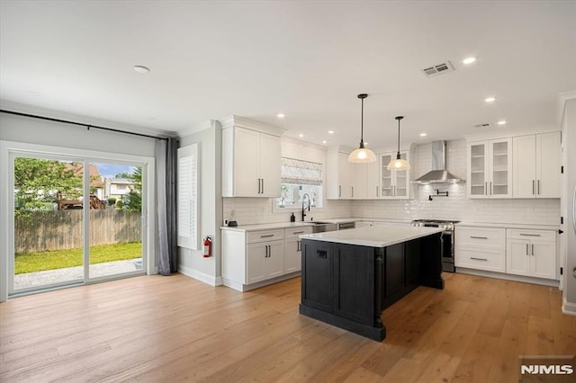 133 Graham Ter, Saddle Brook, NJ 07663 - kitchen with stainless steel range, wall chimney exhaust hood, light countertops, decorative backsplash, and plenty of natural light