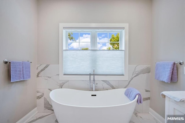 133 Graham Ter, Saddle Brook, NJ 07663 - bathroom featuring marble finish flooring, a soaking tub, tile walls, vanity, and wainscoting