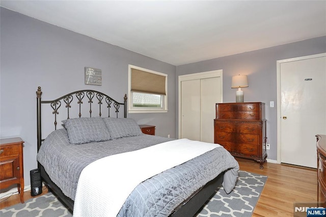 bedroom with baseboards, a closet, and light wood-type flooring