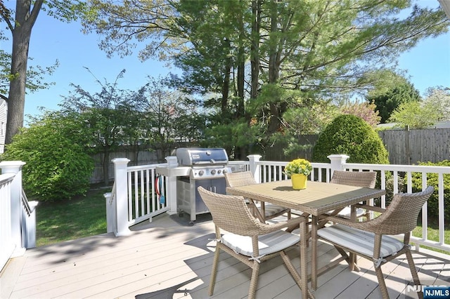 deck with a fenced backyard, a grill, and outdoor dining space