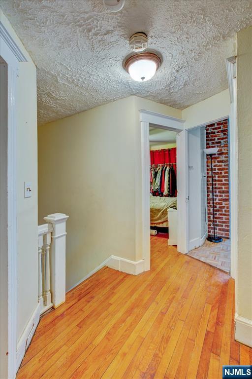 27 Donaldson Ave, Rutherford, NJ 07070 - unfurnished room featuring light wood-style flooring, baseboards, and a textured ceiling