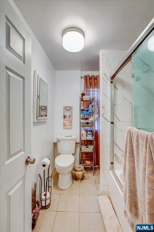 27 Donaldson Ave, Rutherford, NJ 07070 - bathroom with tile patterned flooring, bath / shower combo with glass door, and toilet