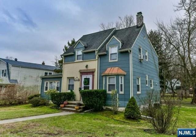 view of front of property with a chimney and a front yard