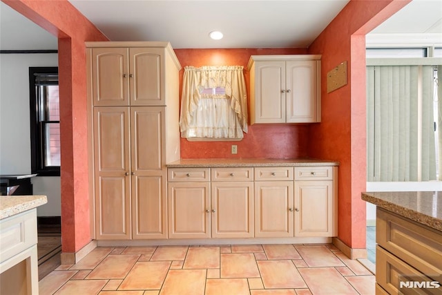 kitchen featuring light stone counters, recessed lighting, and baseboards