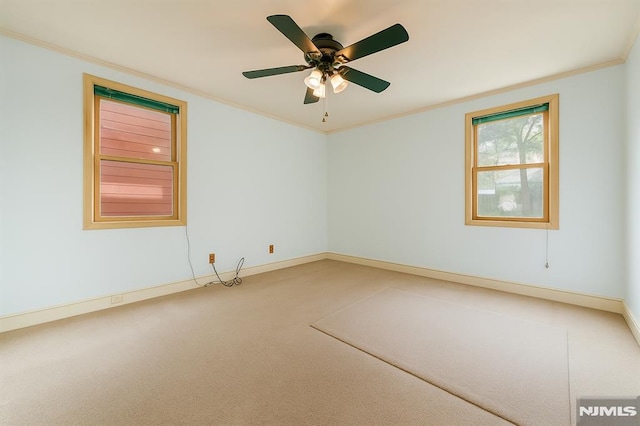 spare room with baseboards, ornamental molding, carpet, and a ceiling fan