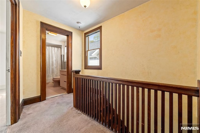 corridor with carpet and an upstairs landing