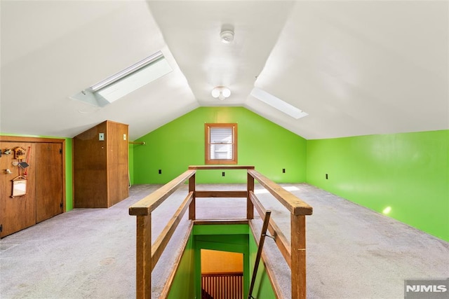 additional living space featuring carpet flooring and lofted ceiling with skylight