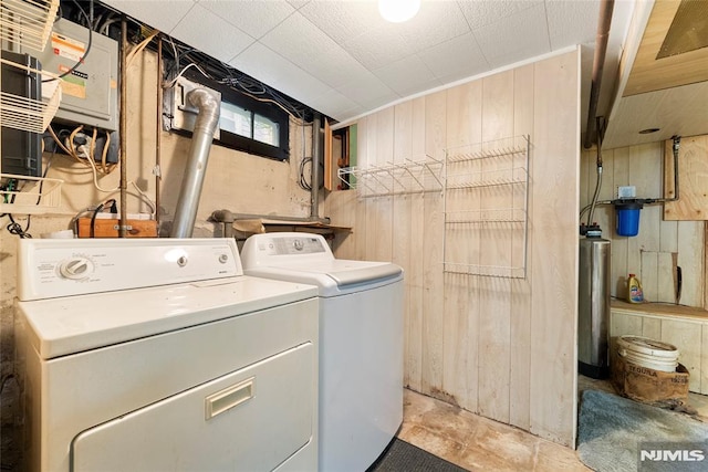 laundry area with laundry area, wood walls, and independent washer and dryer