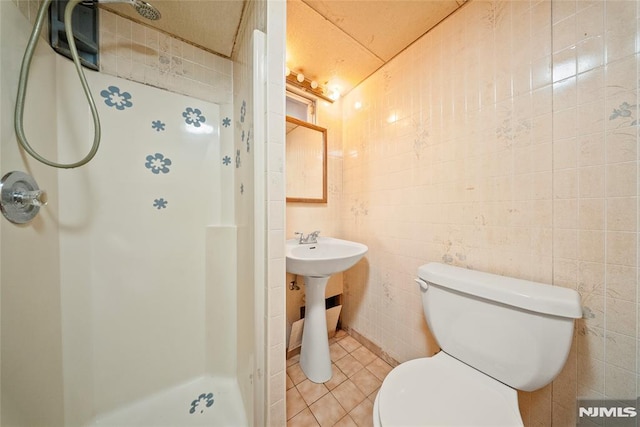 full bathroom with tile patterned floors, toilet, and a shower stall