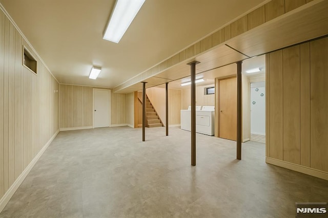 finished below grade area featuring baseboards, washer and clothes dryer, and stairs