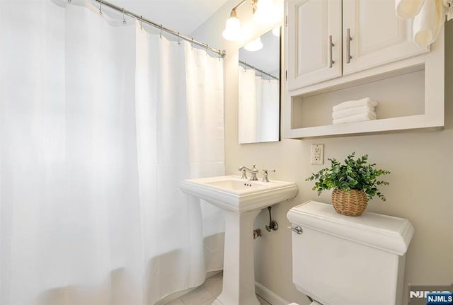 bathroom featuring shower / tub combo, tile patterned floors, and toilet