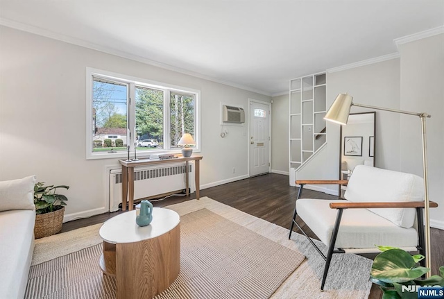 sitting room featuring radiator, baseboards, crown molding, and wood finished floors
