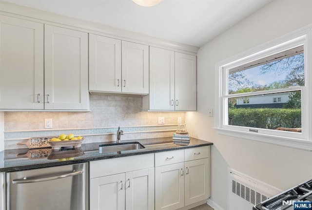 kitchen featuring a sink, dark stone counters, radiator, decorative backsplash, and dishwasher