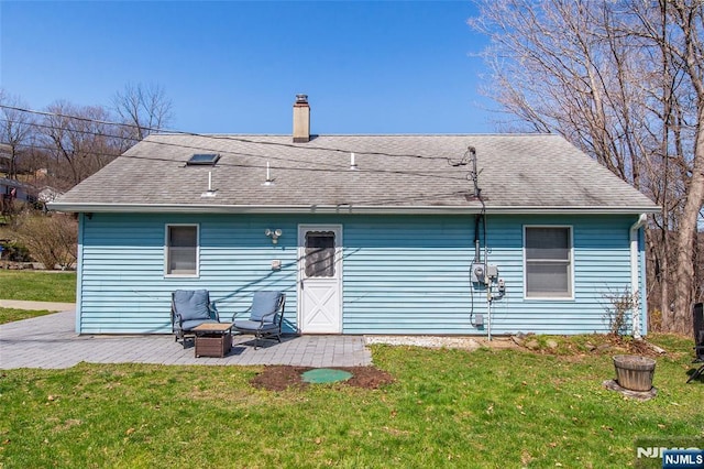 rear view of house with a yard, a patio area, and a chimney