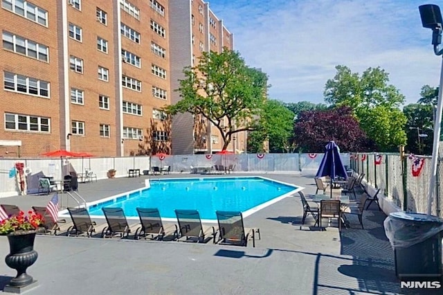 community pool featuring fence and a patio area