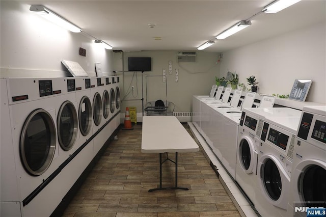 community laundry room featuring washing machine and clothes dryer and dark wood-style floors