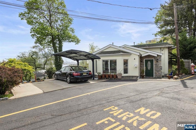 4 Colony Rd, Edgewater, NJ 07020 - view of front of property with a parking lot, stone siding, stucco siding, and fence