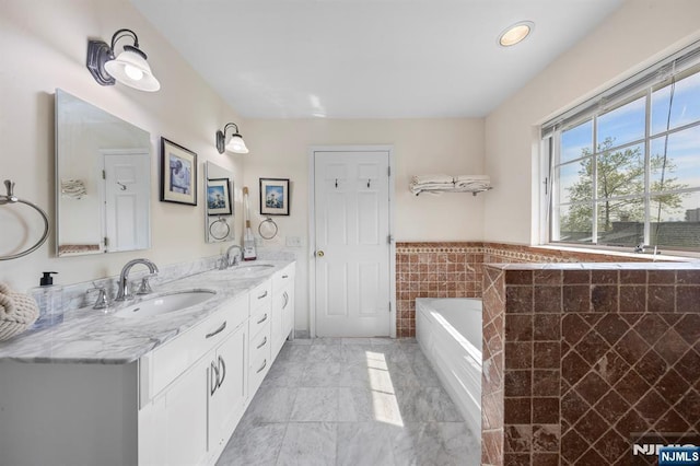 4 Colony Rd, Edgewater, NJ 07020 - bathroom featuring a sink, tile walls, a garden tub, and marble finish floor