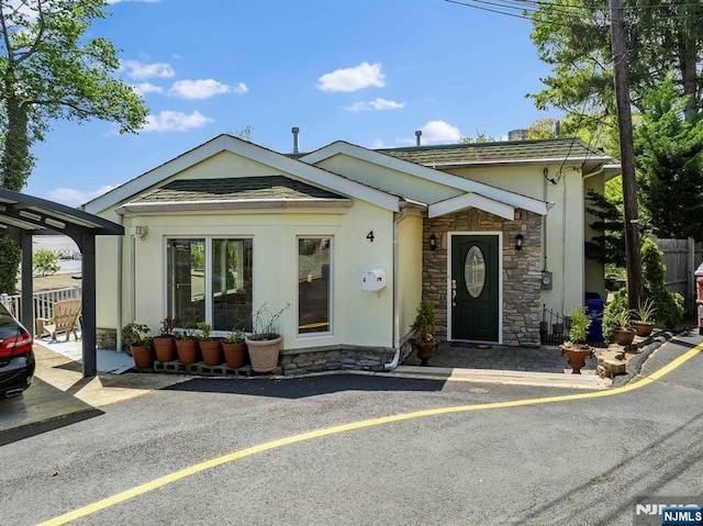 4 Colony Rd, Edgewater, NJ 07020 - view of front of property with stone siding, stucco siding, and fence