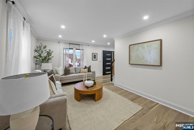 living room featuring light wood-type flooring, recessed lighting, and ornamental molding