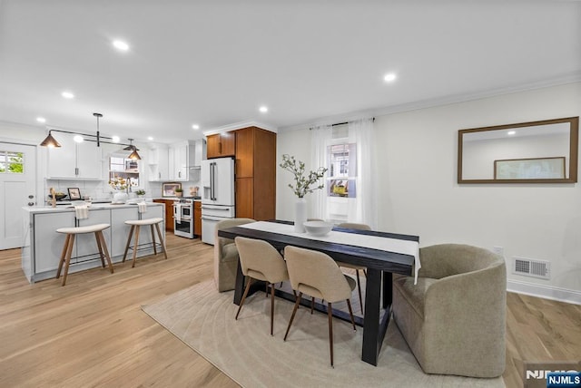 dining room with light wood-style flooring, visible vents, recessed lighting, and crown molding