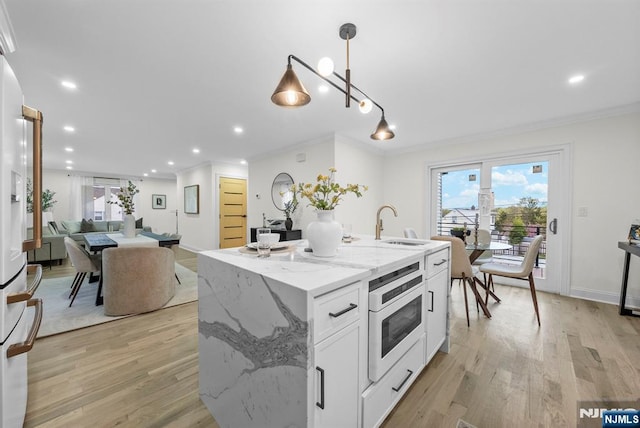 kitchen featuring oven, light wood-style floors, and crown molding