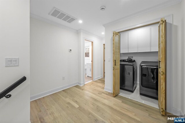laundry room with light wood finished floors, visible vents, cabinet space, separate washer and dryer, and crown molding