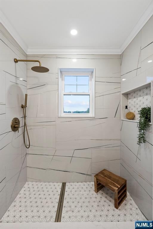 full bathroom featuring tiled shower and ornamental molding