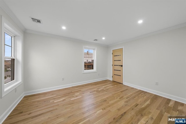 unfurnished room with light wood finished floors, baseboards, visible vents, and ornamental molding