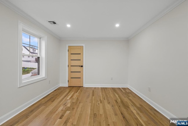 spare room with crown molding, light wood-type flooring, baseboards, visible vents, and recessed lighting