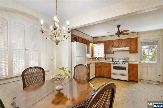 dining space featuring ceiling fan with notable chandelier, a toaster, and light tile patterned flooring