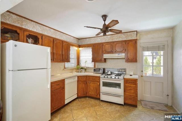 kitchen featuring under cabinet range hood, light countertops, white appliances, brown cabinetry, and ceiling fan