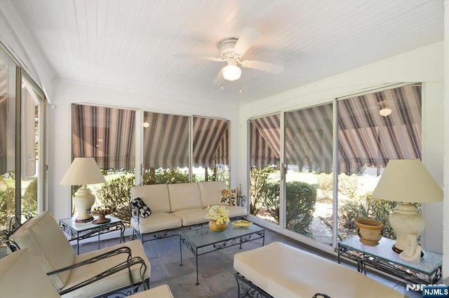 sunroom / solarium with plenty of natural light, a ceiling fan, and an outdoor living space