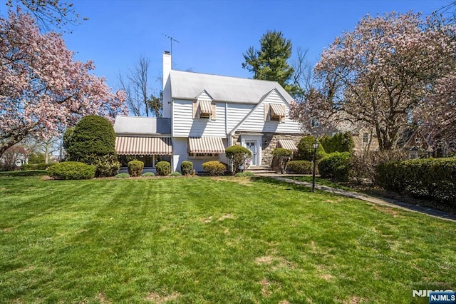 view of front facade with a front lawn and a chimney