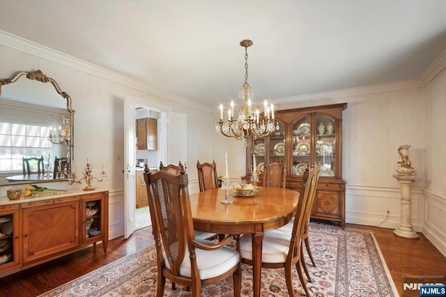 dining space featuring dark wood finished floors, a decorative wall, and a chandelier