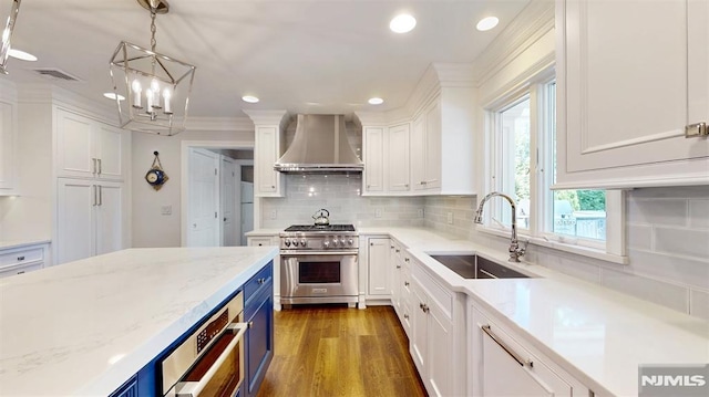 19 Merrill Dr, Mahwah, NJ 07430 - kitchen featuring wall chimney range hood, stainless steel range, a sink, blue cabinetry, and white cabinetry