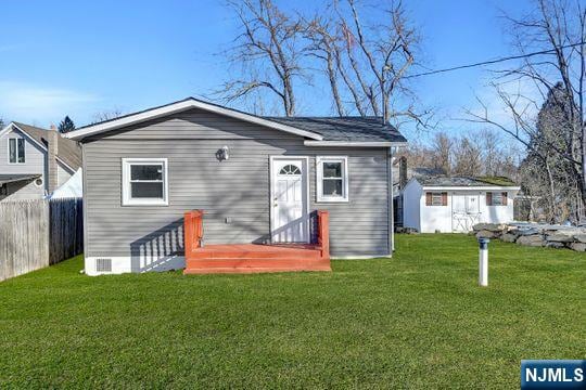 14 Harvey Rd, West Milford, NJ 07421 - back of house featuring a lawn, an outdoor structure, fence, and crawl space