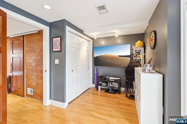 bedroom featuring baseboards, a closet, light wood-type flooring, and visible vents
